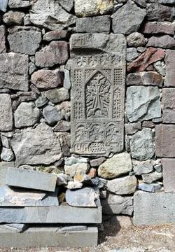 Old-time headstone built into a wall of gray stones Stock Photos