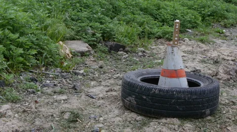 Old tire on the ground with construction cone Stock-Footage 5163155