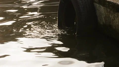 Old tire hanging from pier side and submerged in river, Tortuguero, Costa Rica Stock Footage 141248232