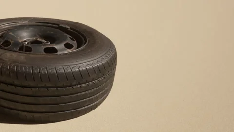 Old Tire Resting on a Flat Surface, Showcasing Its Weathered Texture and Design Stock Footage 344821091
