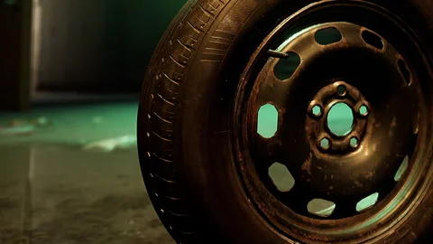 Old Tire Rests on Shiny Surface in Dimly Lit Room Showcasing Unique Textures Stock Footage 344547669