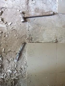 Old tools on floor. Dismantling old floor tiles. Renovations.Chisel and hammer Stock Photos