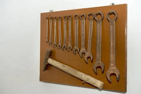 Old tools for men's work. Hammer and wrenches. Hang neatly on the wall. Working Stock Photos