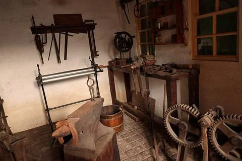 Old tools in the workshop of a craftsman. Blacksmiths workshop. Stock Photos