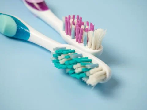 Old toothbrushes on a blue background .used male and female toothbrushes Stock Photos