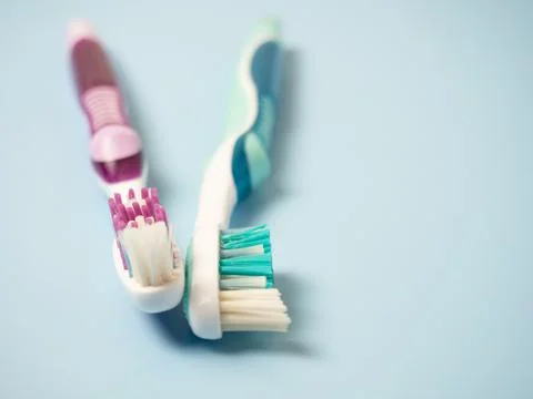 Old toothbrushes on a blue background .used male and female toothbrushes Stock Photos