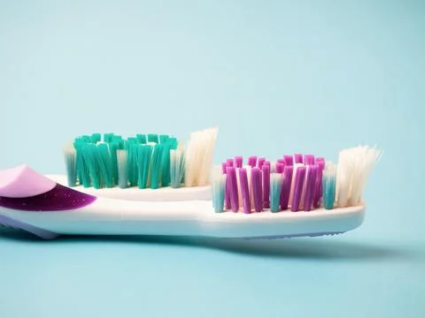 Old toothbrushes on a blue background .used male and female toothbrushes Stock Photos