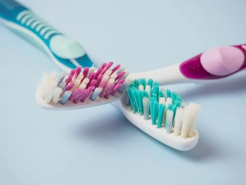 Old toothbrushes on a blue background .used male and female toothbrushes Stock Photos
