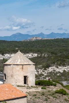 Old tower on the background of mountains, forest and sky with clouds. In the Foto stock