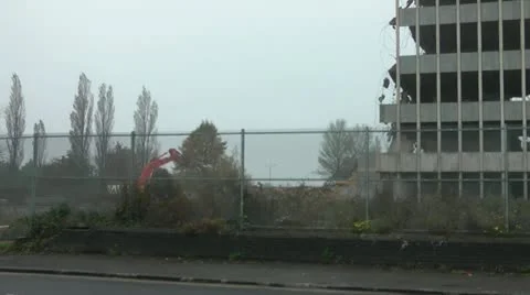 Old tower block undergoing demolition, digger works on rubble pile Stock Footage 14775917