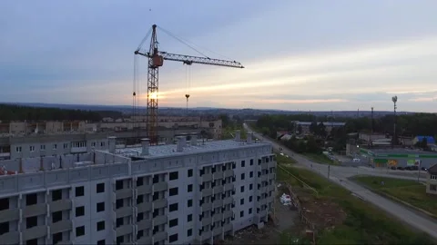 An old tower crane stands motionless near an unfinished house. Video stock 137169318