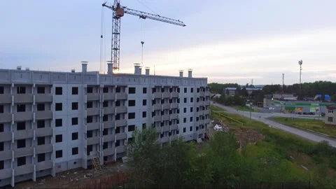 An old tower crane stands motionless near an unfinished house. Stock Footage 137169882