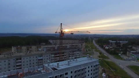 An old tower crane stands motionless near an unfinished house. Video stock 137171195