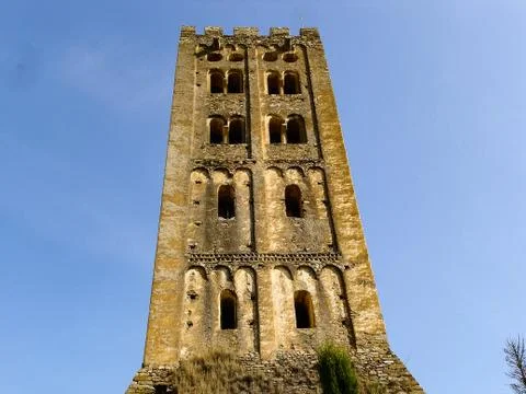 An old tower made of stone in front of the blue sky Stock Photos