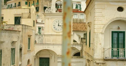 Old town clock on bell tower in Atrani city Amalfi Coast, Italy, viewed through Video stock 305396633