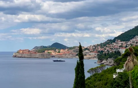 The Old Town of Dubrovnik, walled city, yacht anchored in the Adriatic Sea, 4K Stock Footage