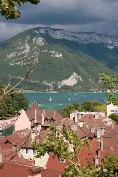 Old town roofs in front and lake and mountains in background. Stock Photos
