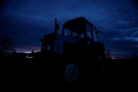 Old tractor on the background of the starry sky Stock Photos
