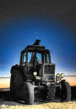 An old tractor on the background of the starry sky. Stock Photos