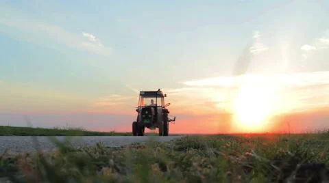 Old tractor passing in the sunset Stock Footage 51682853