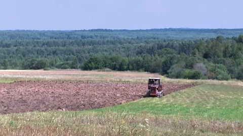 Old tractor plowing the soil. Farmer Stock Footage 85344174