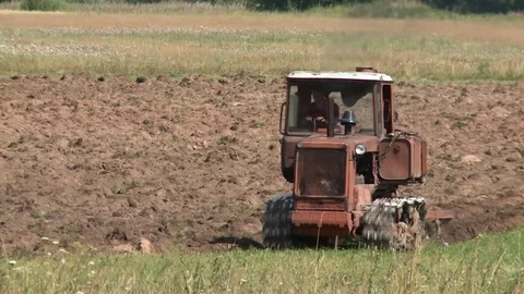 Old tractor plowing the soil. Farmer Stock Footage 85344453
