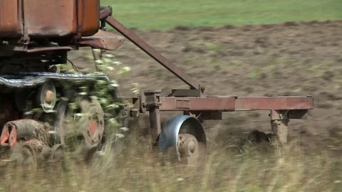 Old tractor plowing the soil. Farmer Stock Footage
