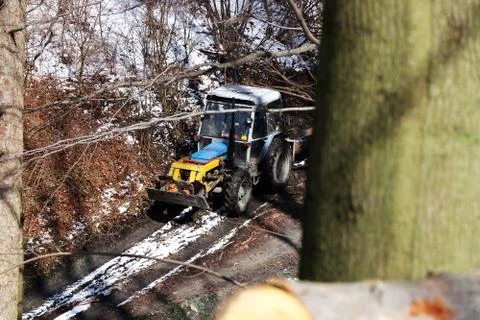 A old tractor pulling logs from mountains to land for next processing in wint Stock Photos