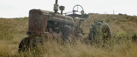 Old tractor rests in tall grass Stock Footage 139331693
