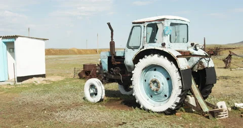 Old tractor, scrap metal, broken agricultural equipment and old car tires. Stock Footage 141784697