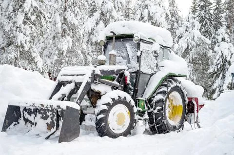 Old tractor still ready to work. Winter snow background. Stock Photos