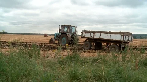 The old tractor with the trailer goes on wheat Stock Footage