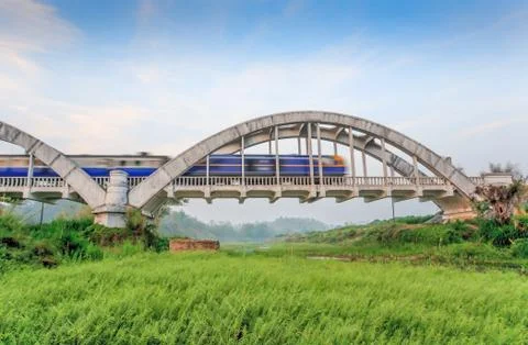 Old train crossing the old white bridge. Stock Photos