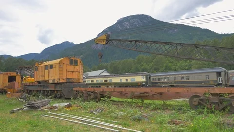 Old Train Graveyard Rail Transport Rusted Crane Machine and Mountain Background Stock Footage 120586911