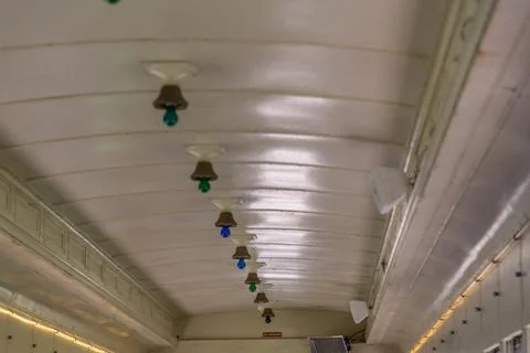 Old train passenger car ceiling with colored light bulbs Stock Photos