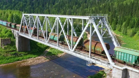 Old train riding on bridge over river in forest Video stock 157859057