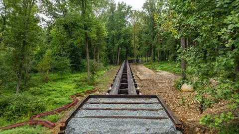 Old Train Track Runs Through Green Forest Area Near Wooded Path With No Tra.. Stock Photos