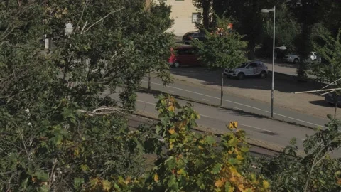Old Tram Passing Behind Tree Foliage in Gothenburg, Sweden, High Angle View Vídeos de archivo 219611498