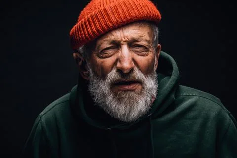 Old tramp man looks at camera with screwed up eyes and interrogative expression 스톡 사진