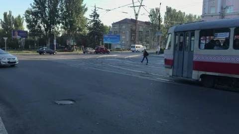 Old trams in Ukraine pull up to a stop people cross the road Stock Footage 241186840