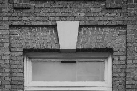 Old transom window and solid brick in monochrome Stock Photos