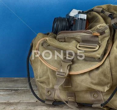Old travel backpack and camera Stock Photos