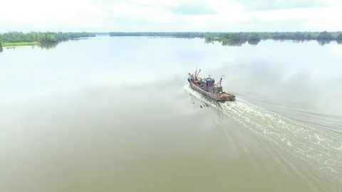 Old trawler passing by stranded boat Stock Footage 81370824