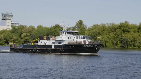Old tug pushes a barge down a work on the river inscription on board "Puteisk Stock Footage 136131359