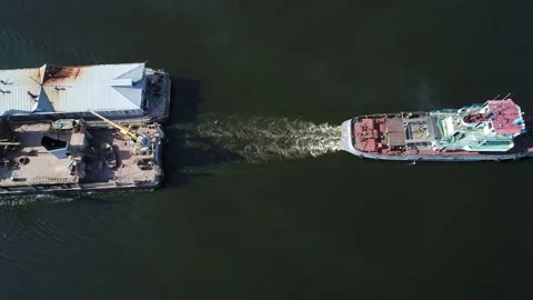 An old tugboat pulls a floating construction base and dredging equipment  스톡 동영상 235570756