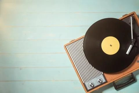 Old turntable with a vinyl record on rustic wooden table 写真素材