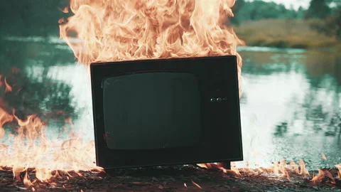 Old TV burns with fire. Behind is pond that is also burning with flames Stock Footage 160152248