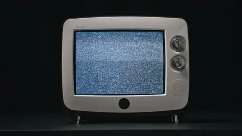 Old TV flickering screen standing table at black background closeup. White noise Stock Footage 332670011