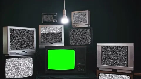 Old TV sets with static turned on Green screens. Lots of chromakey TVs in a dark Stock Footage 164838678