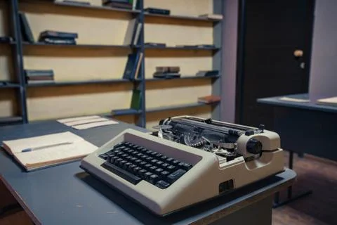 Old typewriter on grey table and books on background Stock Photos